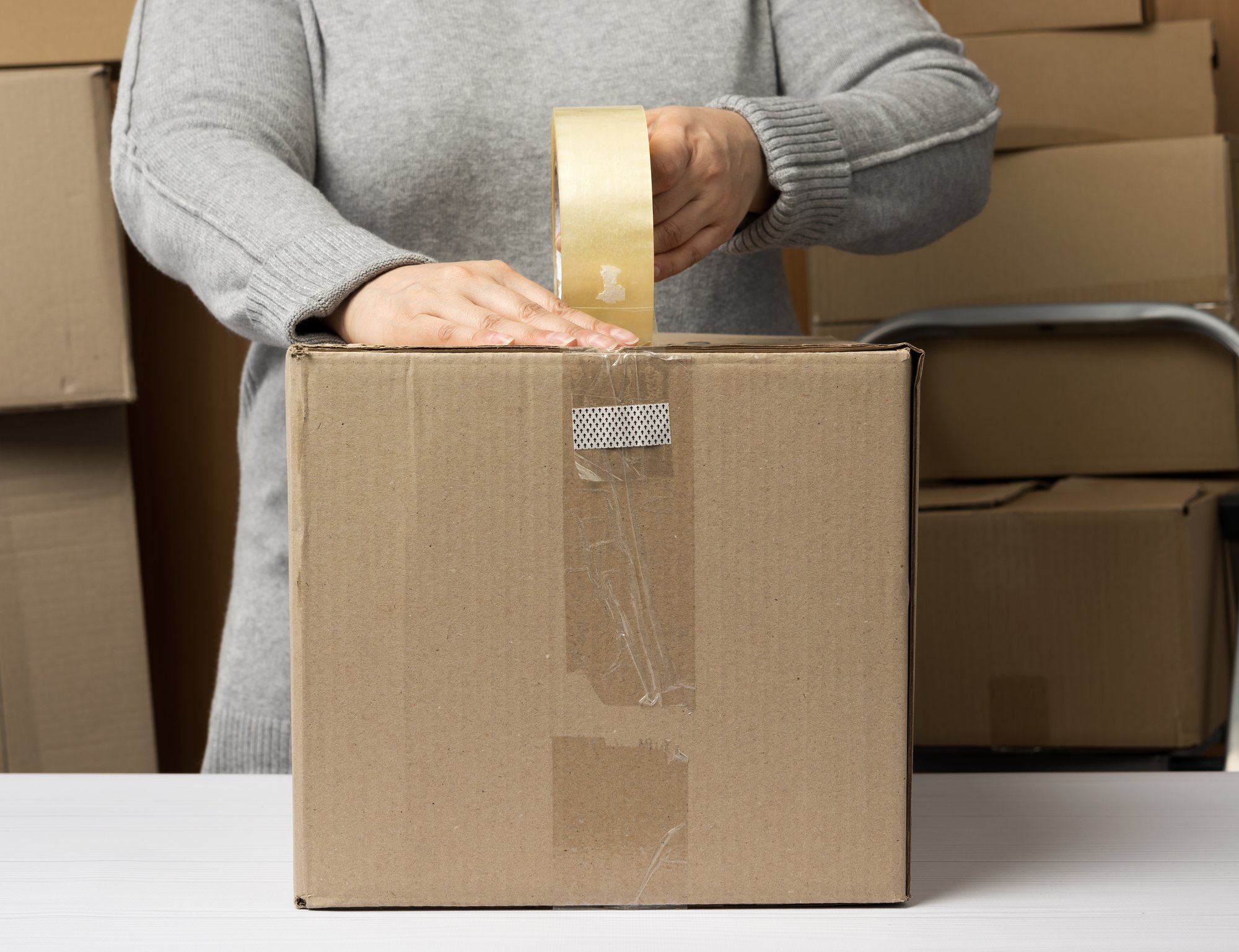 woman-in-a-gray-sweater-holds-a-roll-of-duct-tape-2025-03-24-03-16-24-utc
